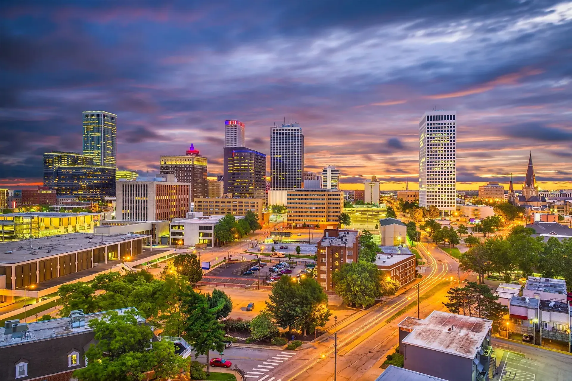 an aerial view of a city at night with a sunset in the background .
