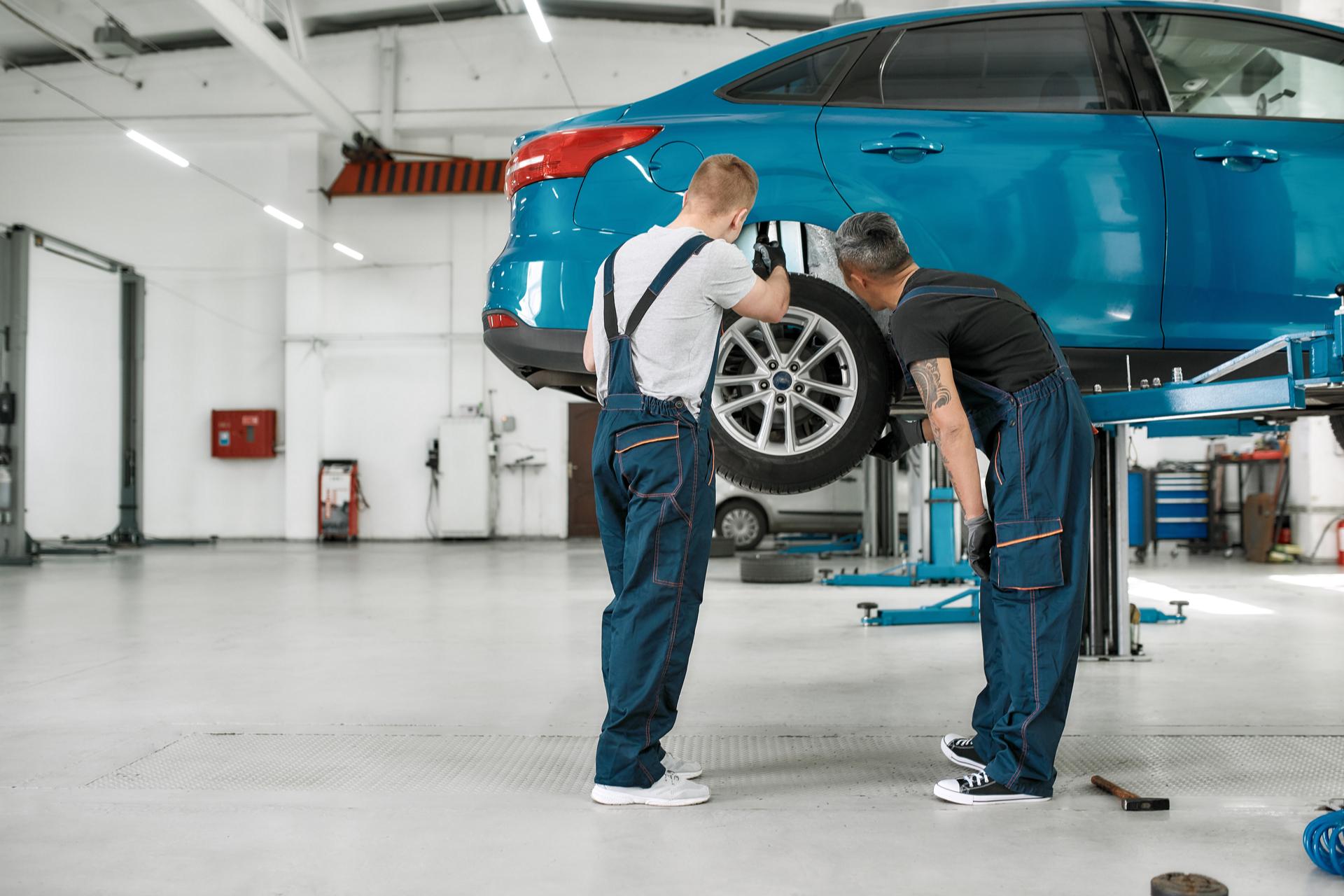 car workers inspect car tires
