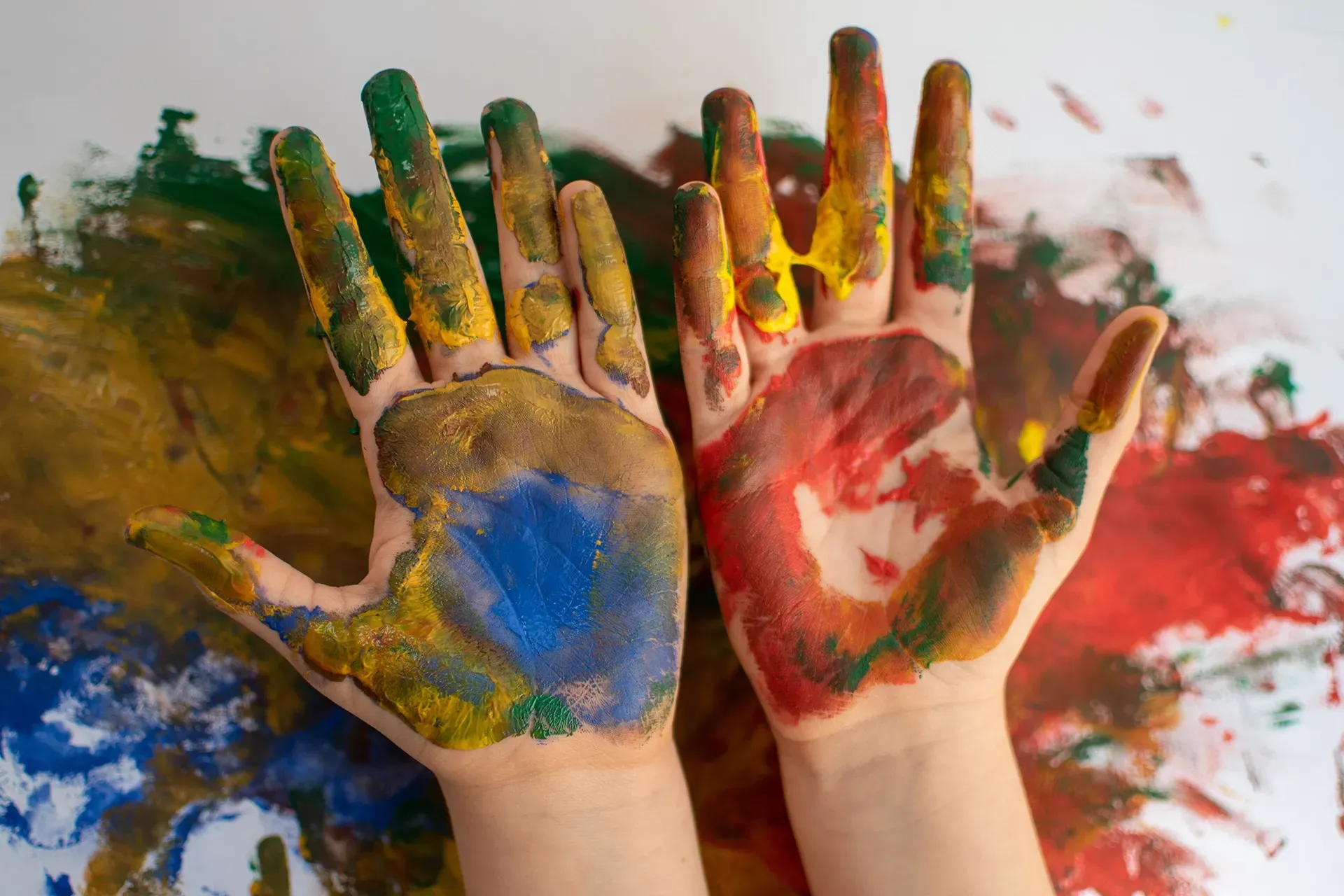 Die Hände eines Kindes sind in verschiedenen Farben bemalt.