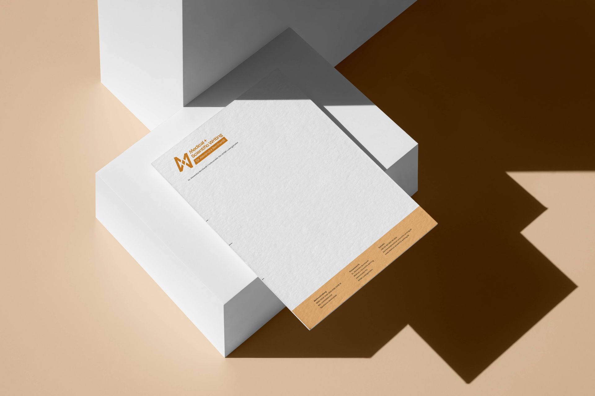 Auf einem Stapel weißer Kartons liegt Briefpapier.