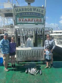 A family is posing for a picture on the deck of a boat.