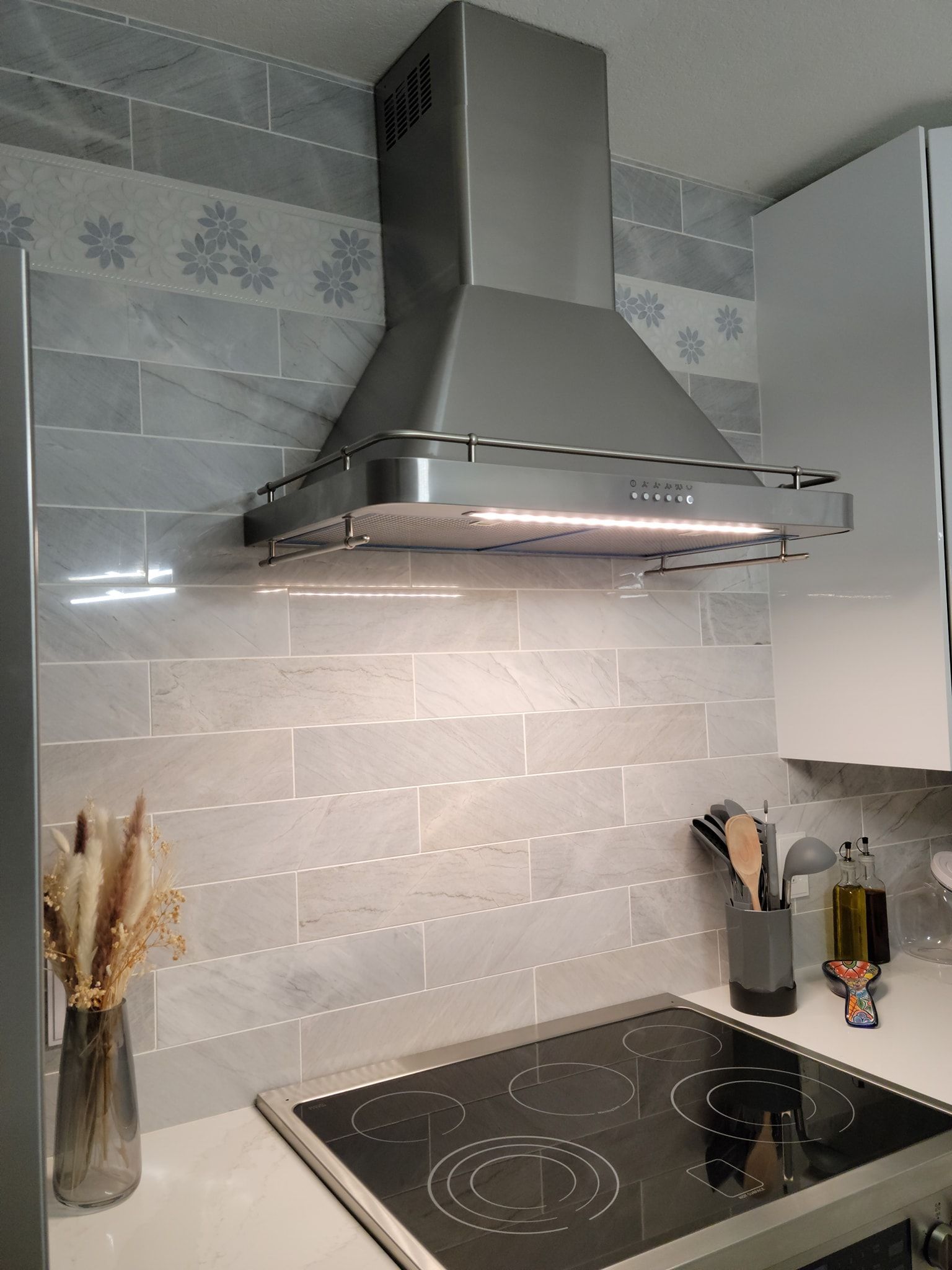 A kitchen with a stove top oven and a hood above it.