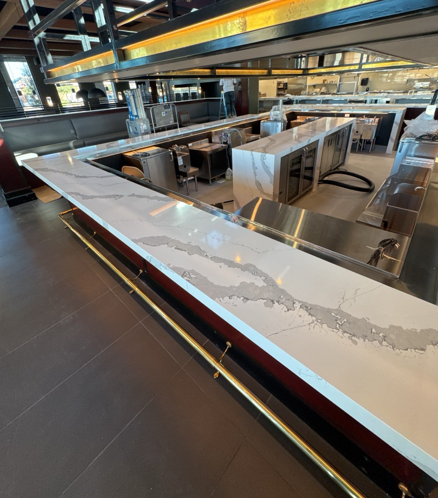 Woman in straw hat smiles, holding wine glass near a lake.