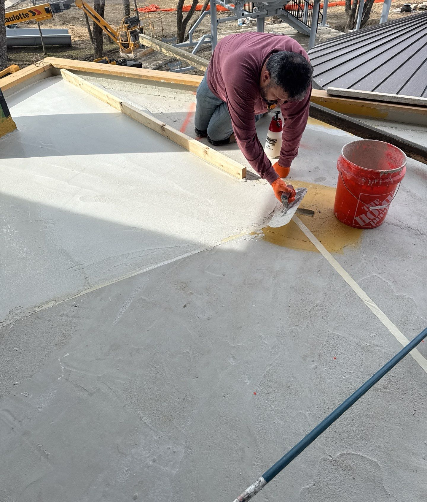 Woman in straw hat smiles, holding wine glass near a lake.