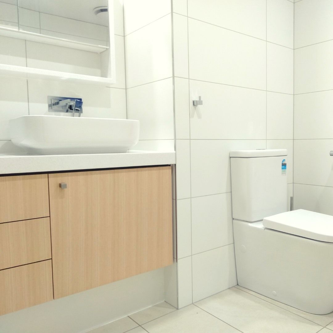 White Bathroom With a Wooden Vanity and a Modern Toilet — Nyblad Construction in Maroochydore, QLD
