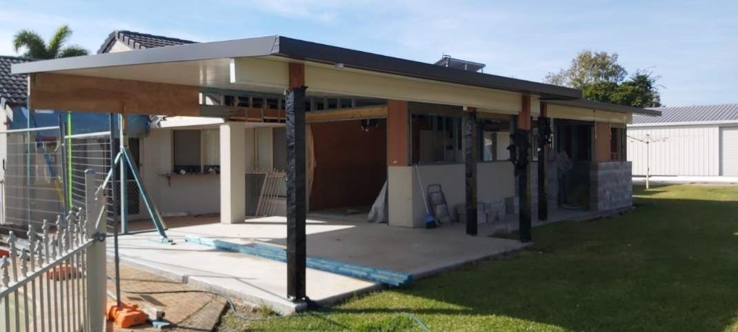 A Covered Patio Under Construction With Black Posts, a Light Roof, and a Grassy Backyard — Nyblad Construction in Buderim, QLD