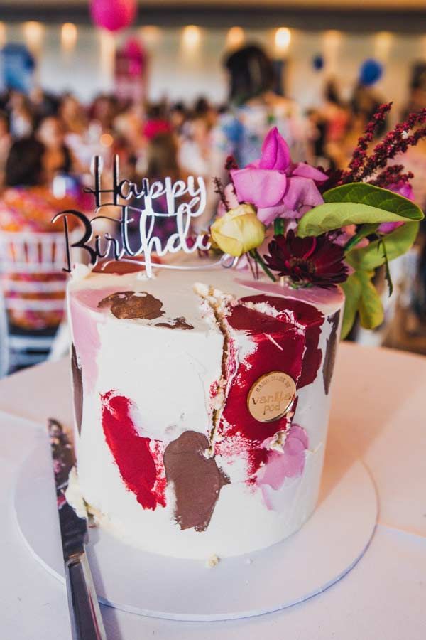 A Birthday Cake With Flowers On It Is Sitting On A Table — Nyblad Construction in Caloundra West, QLD
