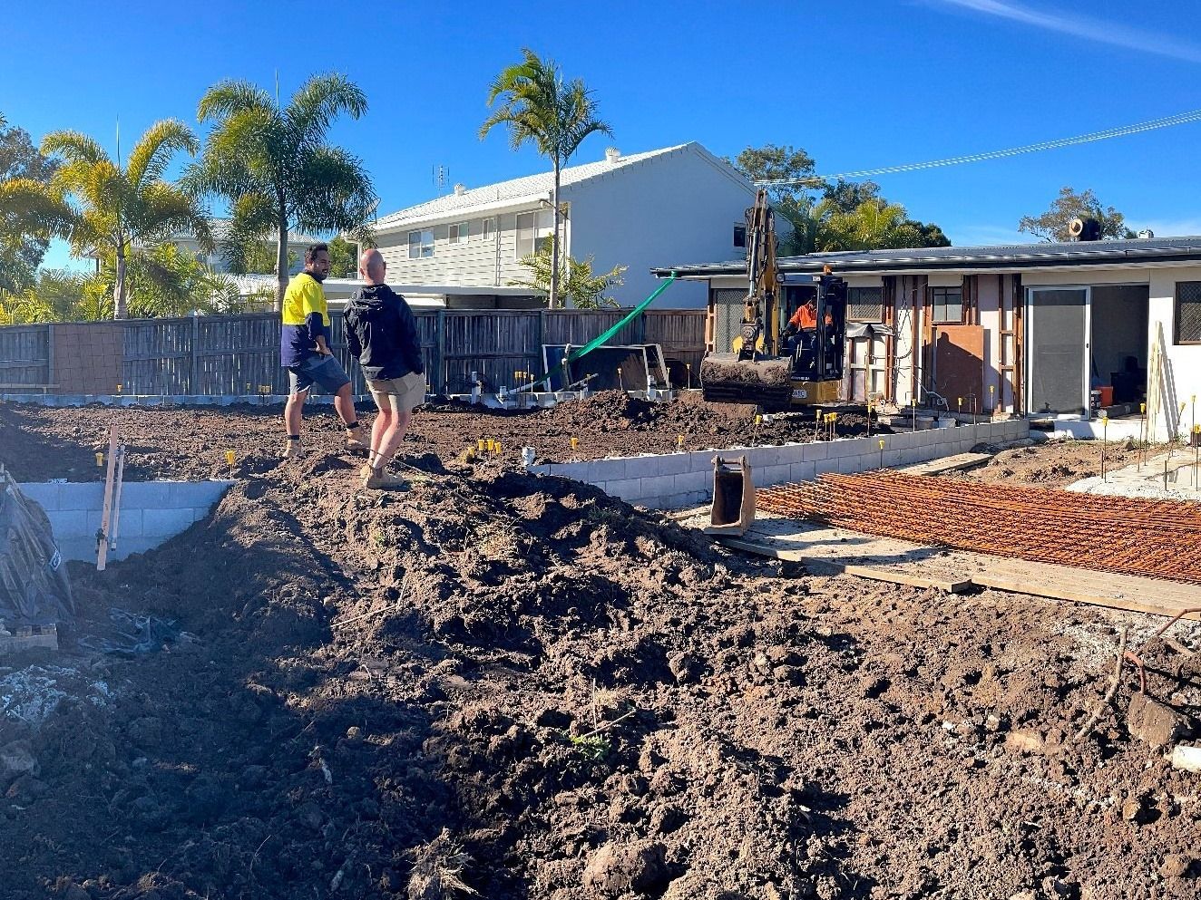 Construction Site With Workers, Excavator, Dirt, Brickwork, and a Building — Nyblad Construction in Buderim, QLD