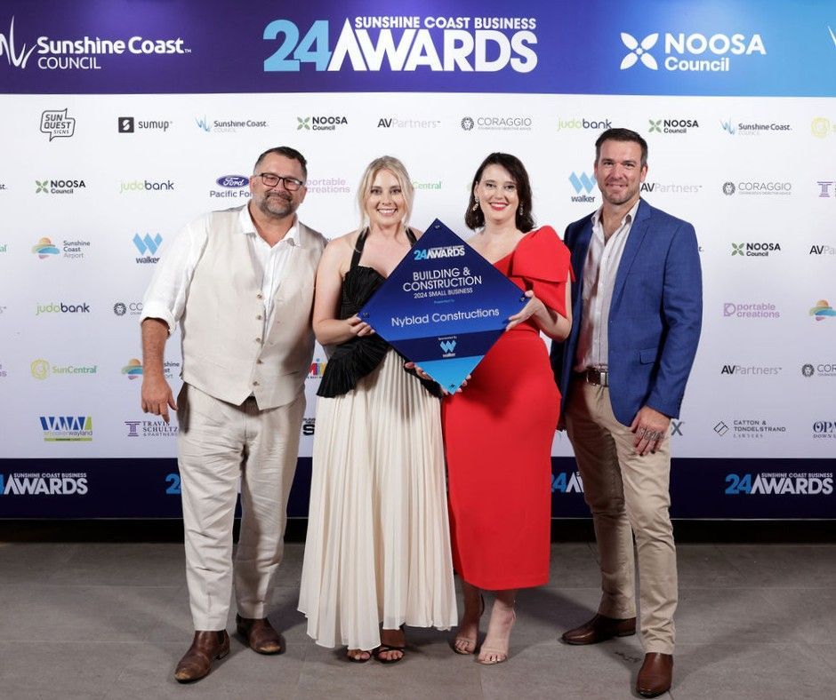 A Group of People Are Posing for a Picture in Front of a 24 Awards Sign — Nyblad Construction in Caloundra West, QLD