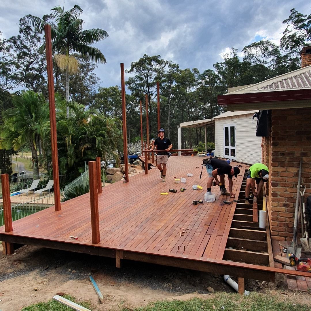 People Building a Wooden Deck Outdoors Near a House — Nyblad Construction in Caloundra, QLD