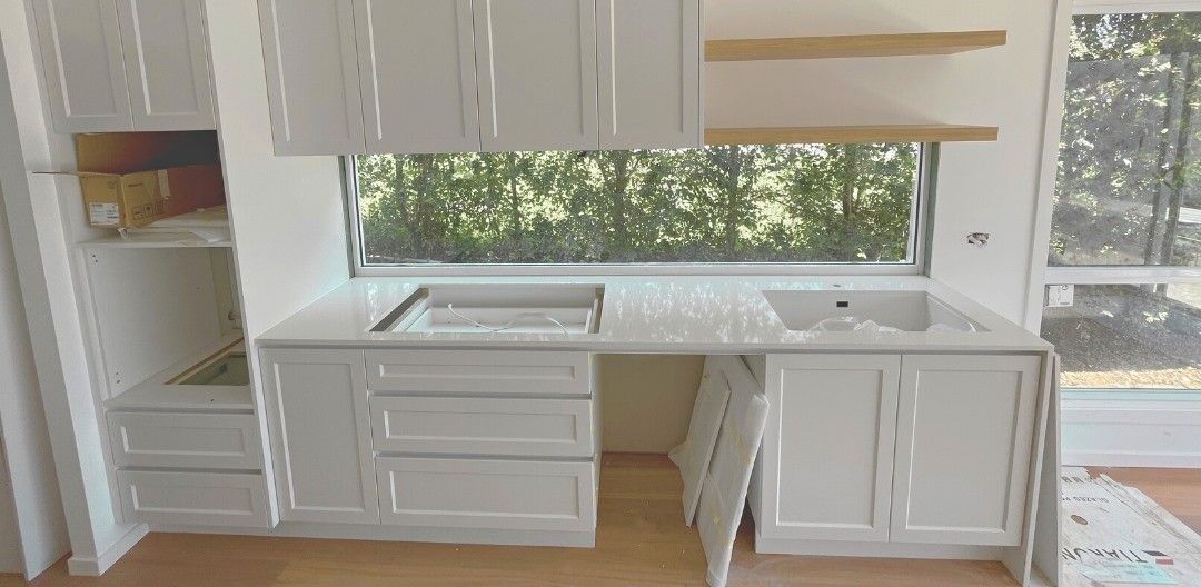 White Kitchen Cabinets Under a Large Window, With Natural Light — Nyblad Construction in Caloundra, QLD