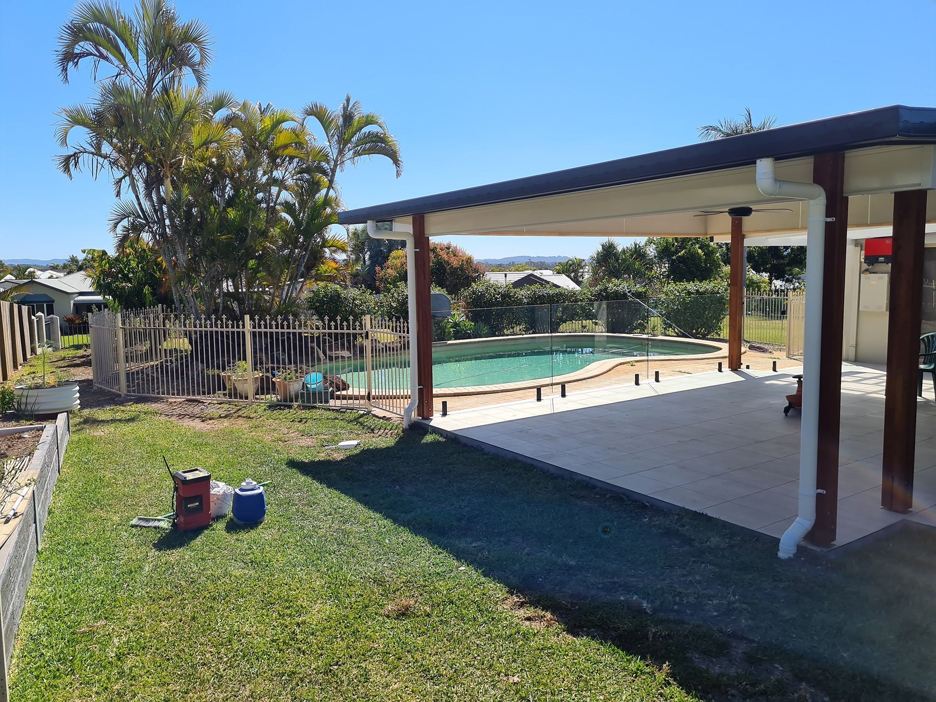 Backyard With a Pool, Covered Patio, Green Lawn, and a Sunny Sky — Nyblad Construction in Coolum, QLD