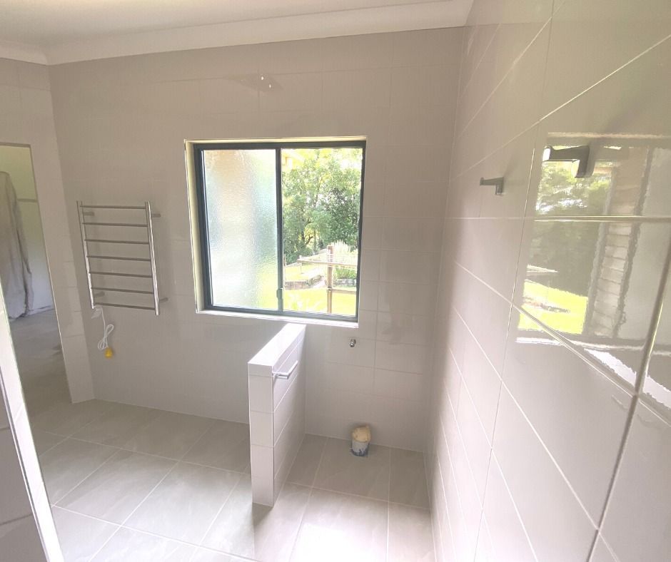 Modern Room With a Fireplace, Large Window With a View of Trees — Nyblad Construction in Maroochydore, QLD