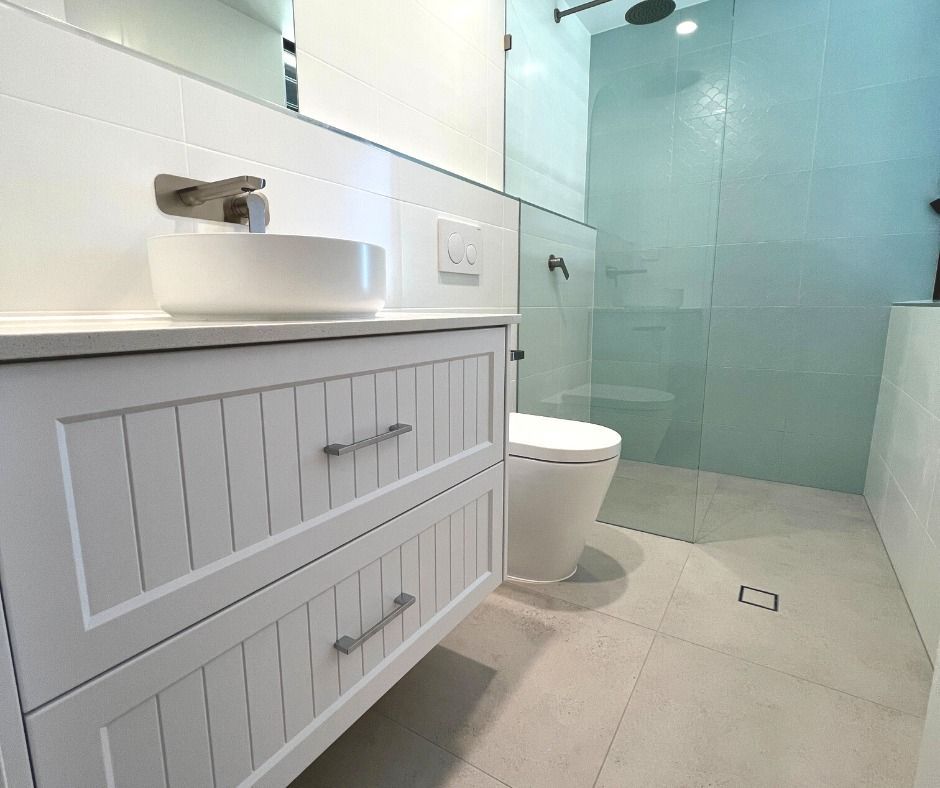 White Bathroom With Vanity, Toilet, and Glass Shower — Nyblad Construction in Coolum, QLD
