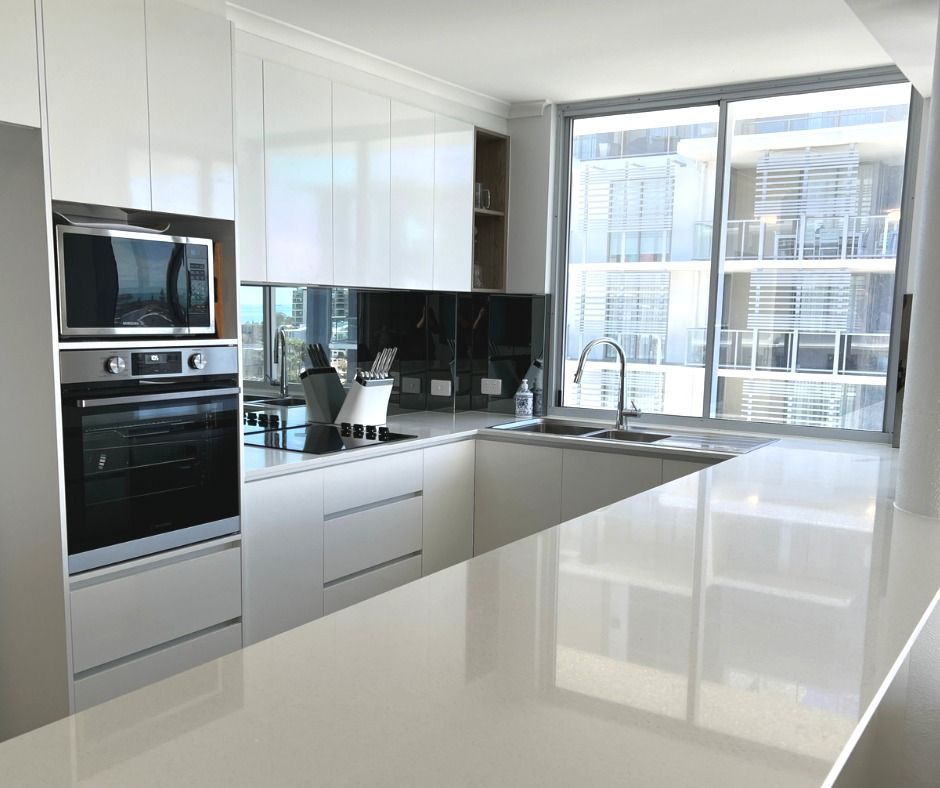 Modern Kitchen With White Cabinets, Stainless Steel Appliances, and Large Window — Nyblad Construction in Buderim, QLD