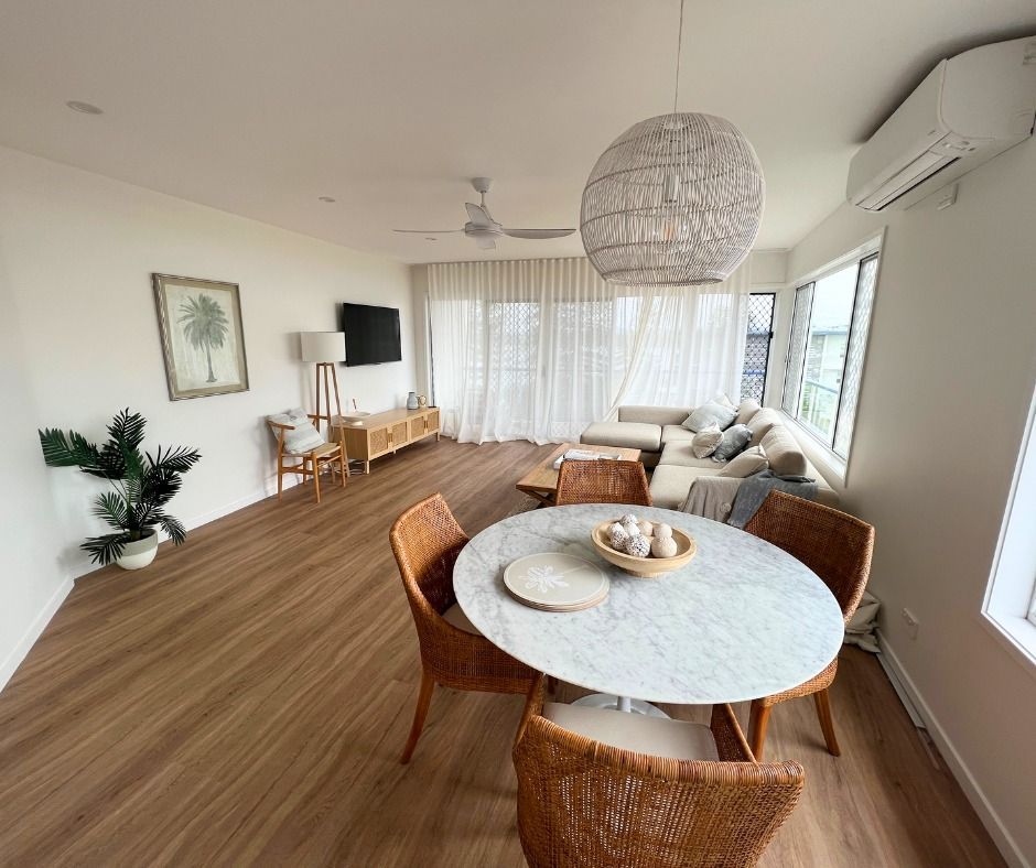 Living Room With Round Dining Table, Chairs, Sofa, TV, and Large Windows — Nyblad Construction in Buderim, QLD