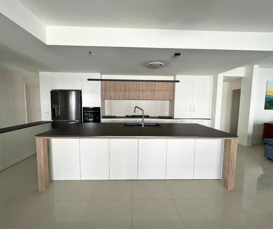 Modern Kitchen With Large Island, White Cabinets — Nyblad Construction in Maroochydore, QLD