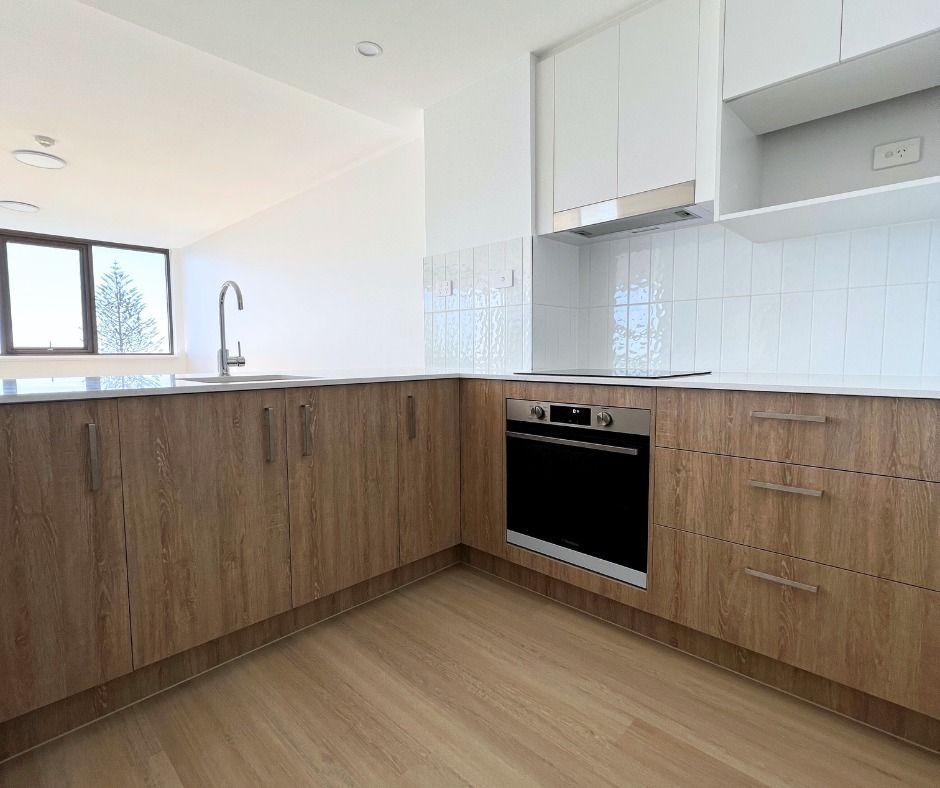 Modern Kitchen With Wood-grain Cabinets, White Countertops, and White Backsplash — Nyblad Construction in Buderim, QLD