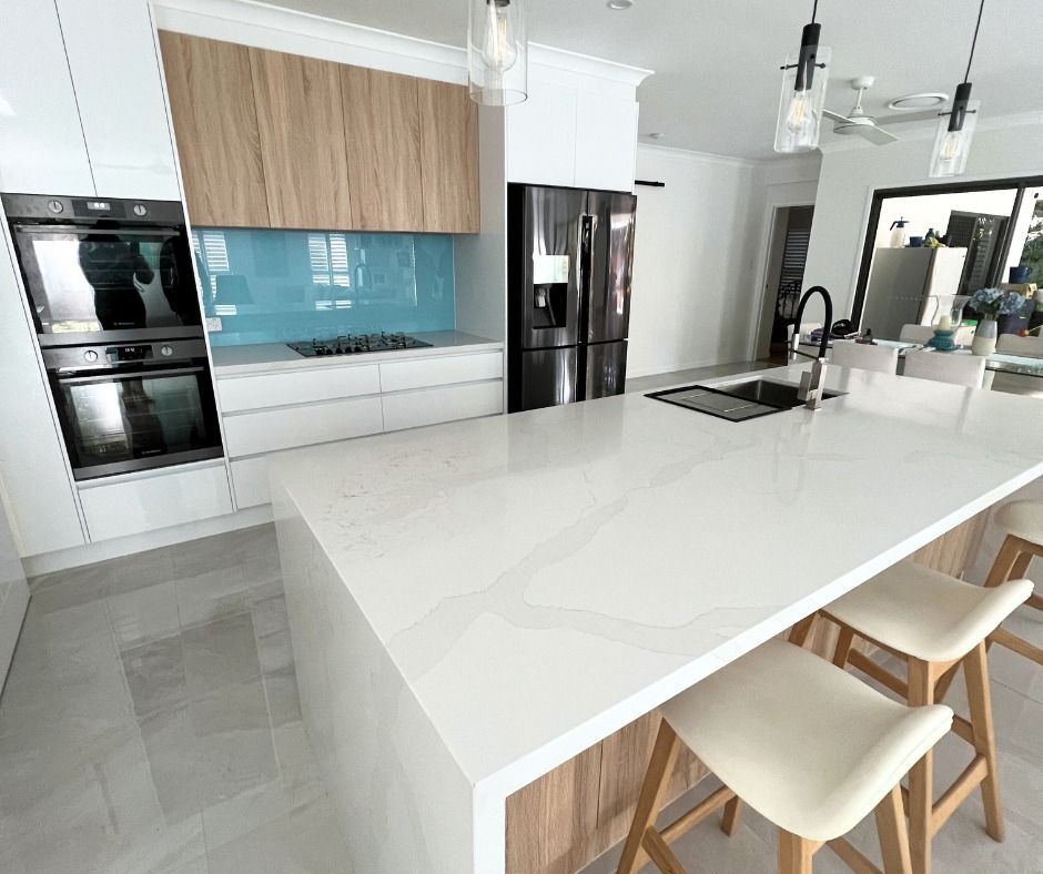 Modern Kitchen With White Countertops and Wooden Cabinets — Nyblad Construction in Coolum, QLD