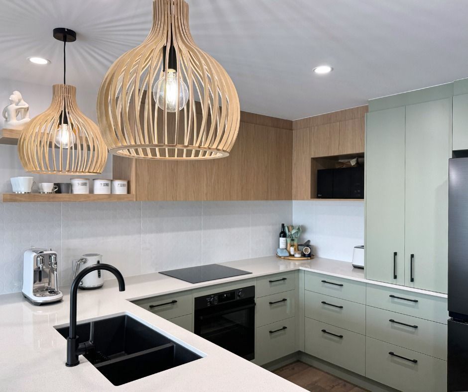 Modern Kitchen With Light Green Cabinets, Wood Accents, and Pendant Lights — Nyblad Construction in Caloundra West, QLD