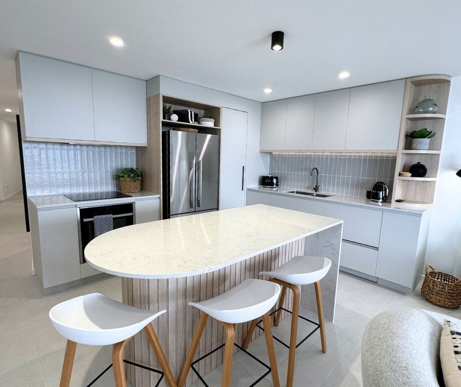 Modern Kitchen With White Cabinets, Island, and Stools — Nyblad Construction in Maroochydore, QLD