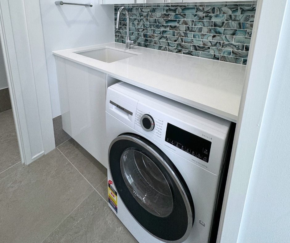 Laundry Room With a White Washing Machine and Countertop Sink — Nyblad Construction in Caloundra West, QLD