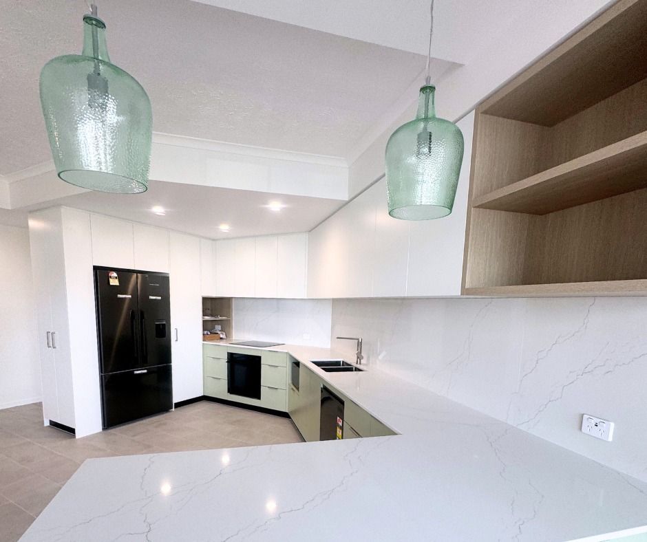 Modern Kitchen With White Counters, Cabinets, and Green Pendant Lights — Nyblad Construction in Buderim, QLD