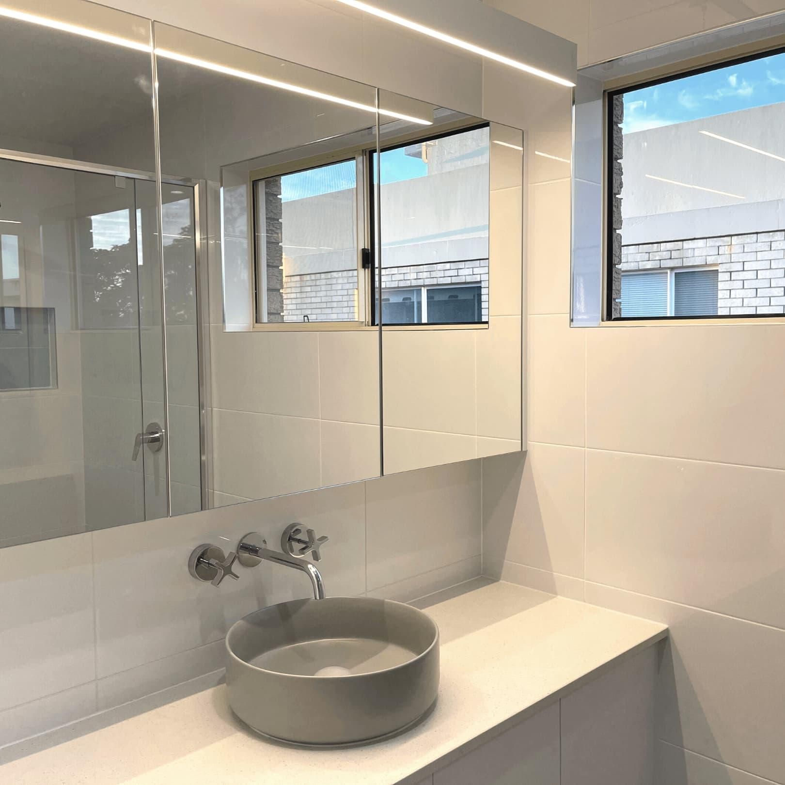 Bathroom With a Sink, Mirror and Window — Nyblad Construction in Caloundra West, QLD