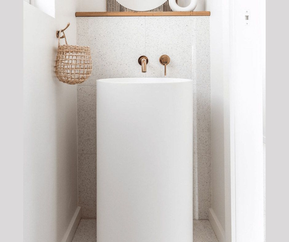 A Bathroom With A Pedestal Sink And A Mirror — Nyblad Construction in Caloundra West, QLD