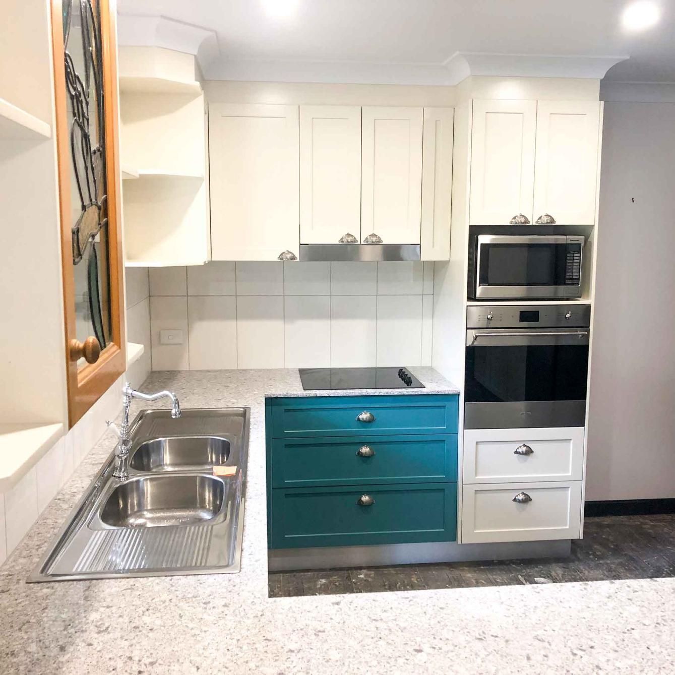 Kitchen With White Cabinets and Blue Drawers — Nyblad Construction in Caloundra West, QLD
