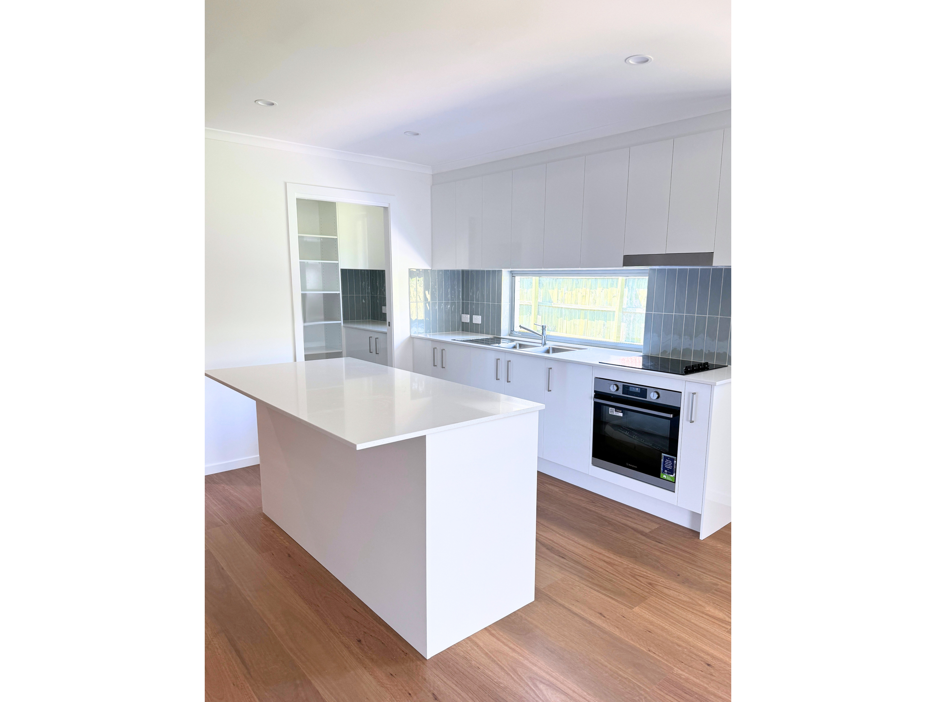 A Kitchen With White Cabinets And A White Bench— Nyblad Construction in Caloundra West, QLD