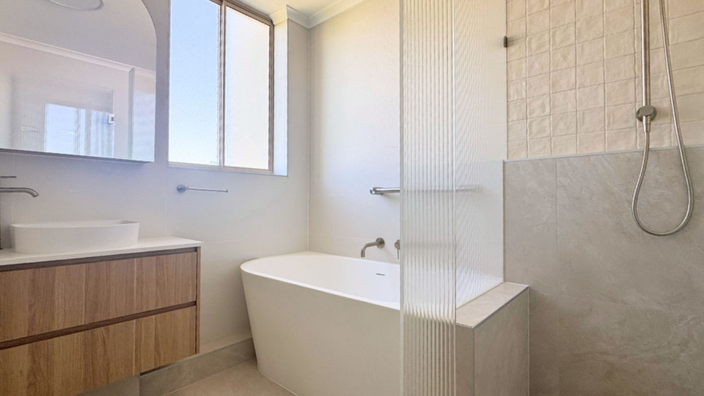 Modern Bathroom With a White Tub, Shower, Vanity, and Window — Nyblad Construction in Caloundra West, QLD