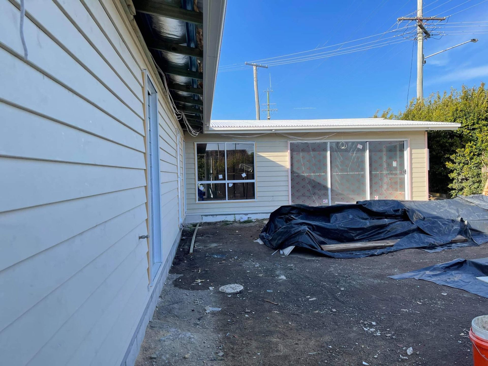 Exterior view of a house with siding and windows, construction materials on the ground. — Nyblad Construction in Maroochydore, QLD