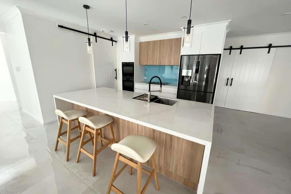 Kitchen With a Large Island, Stools and a Refrigerator — Nyblad Construction in Caloundra West, QLD