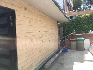 A Wooden Building With A Black Door Is Being Built — Nyblad Construction in Caloundra West, QLD