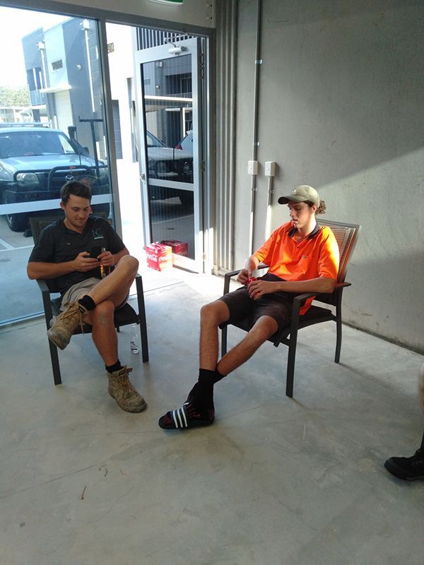 Two Men Are Sitting In Chairs With Their Legs Crossed — Nyblad Construction in Caloundra West, QLD