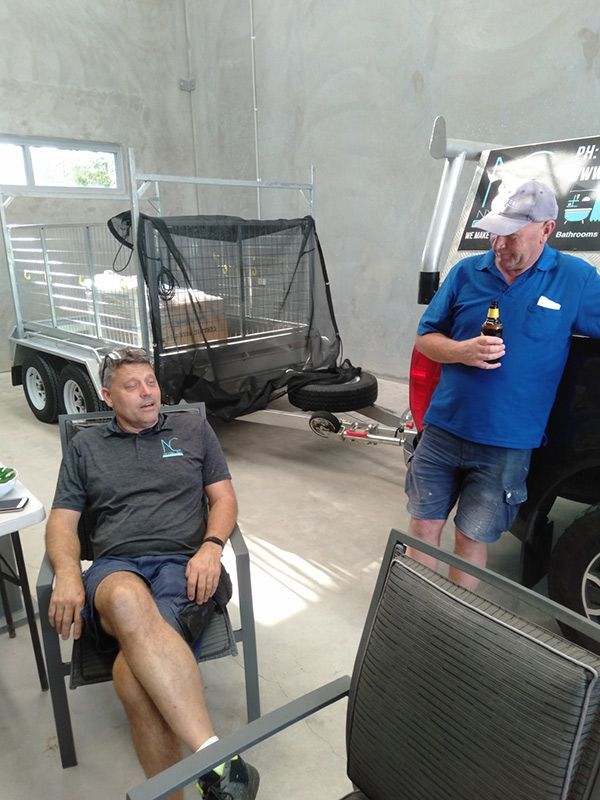Two Men Are Sitting In Chairs In Front Of A Trailer — Nyblad Construction in Caloundra West, QLD