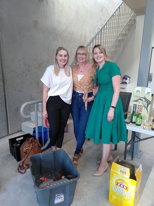 Three Women Are Posing In Front Of A Staircase — Nyblad Construction in Caloundra West, QLD