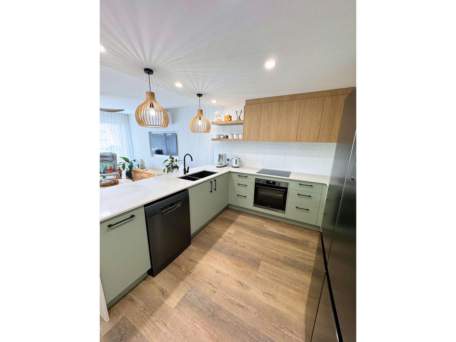 A Kitchen With Green Cabinets And Hanging Lights — Nyblad Construction in Caloundra West, QLD