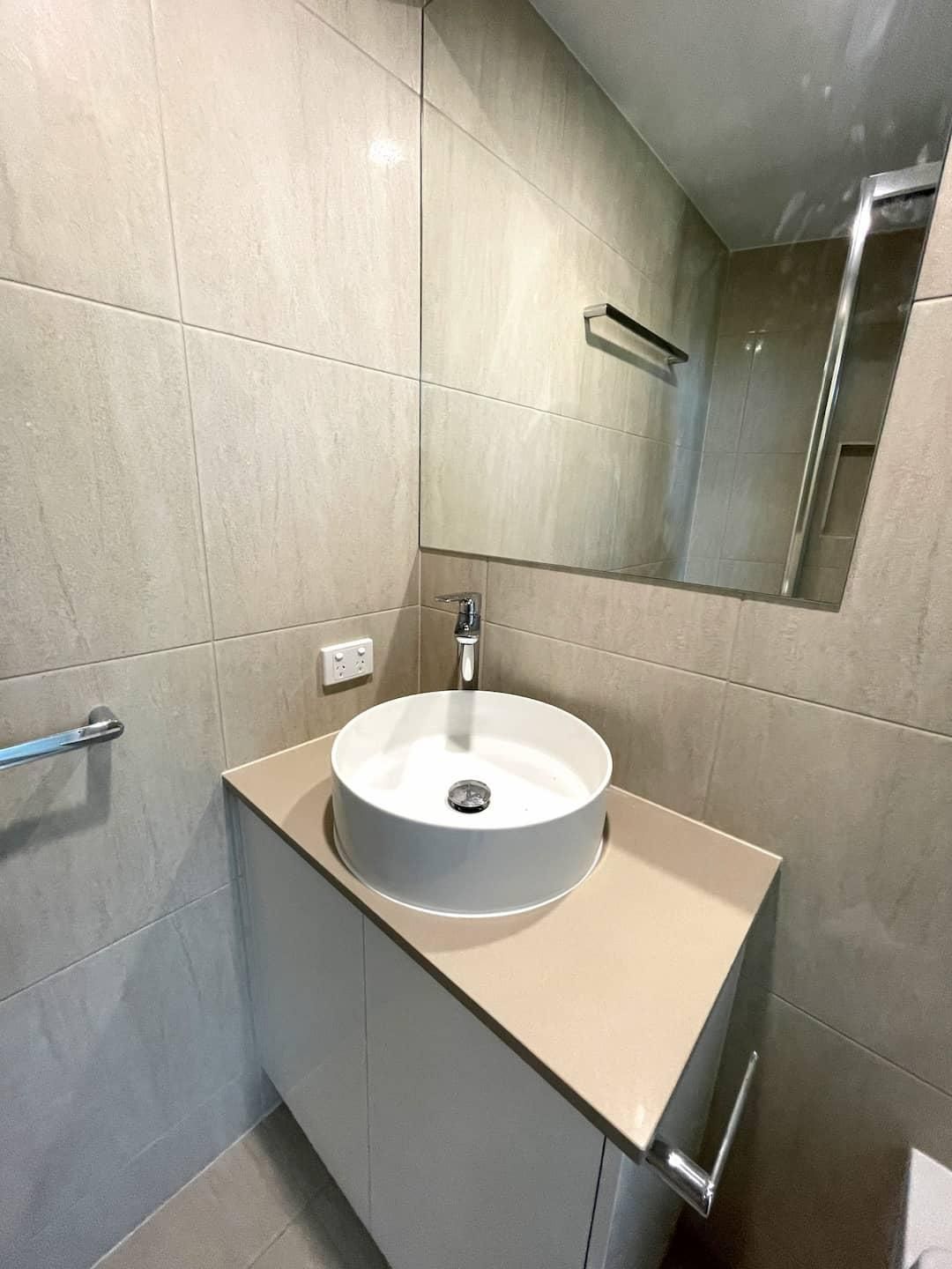 Bathroom With a Round Sink and a Mirror — Nyblad Construction in Caloundra West, QLD