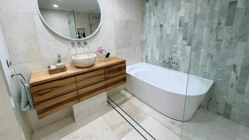 A bathroom with a bathtub , sink , mirror and walk in shower.