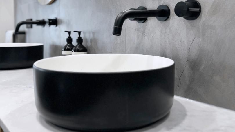 A black and white sink is sitting on a counter in a bathroom.