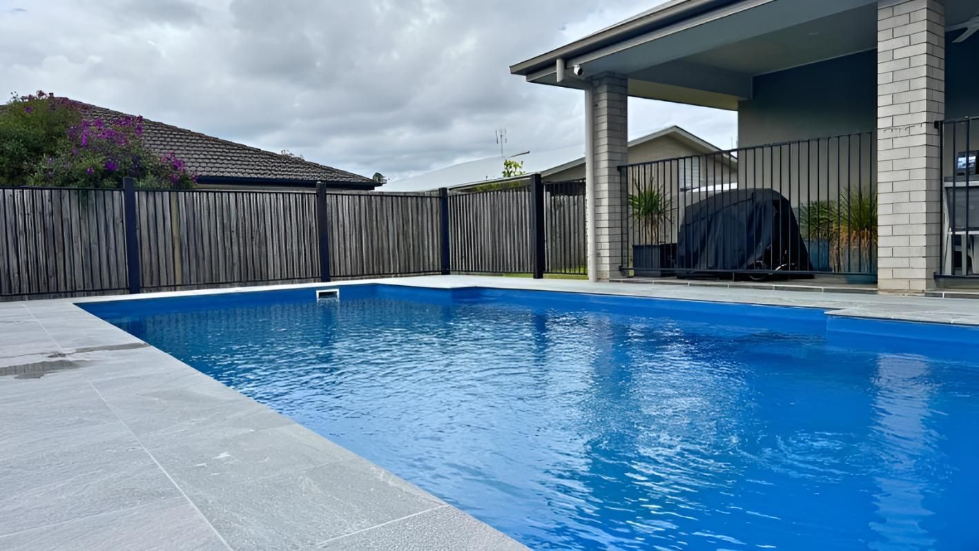 There is a Large Swimming Pool in the Backyard of a House — Nyblad Construction in Caloundra West, QLD