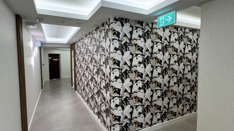 Hallway With a Green Exit Sign on the Ceiling — Nyblad Construction in Caloundra West, QLD