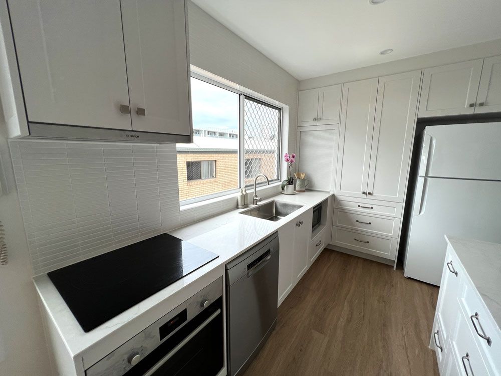 With White Cabinets, Stainless Steel Appliances, A Sink, And A Refrigerator — Nyblad Construction in Caloundra West, QLD