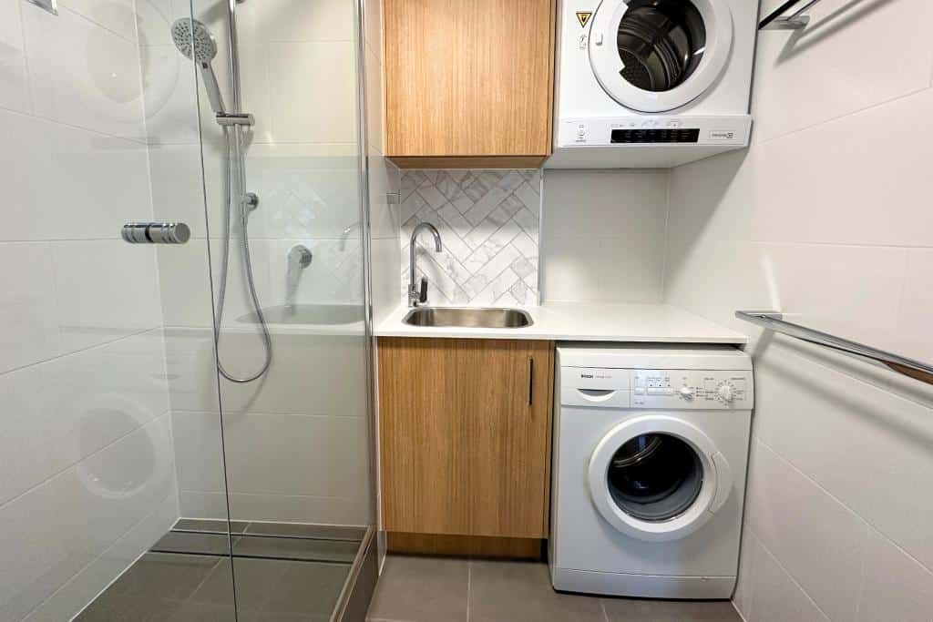 Laundry Room With a Washer and Dryer and a Shower — Nyblad Construction in Caloundra West, QLD