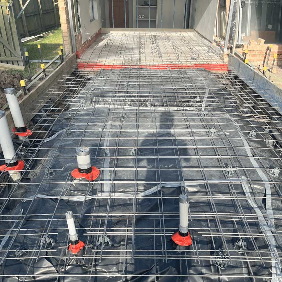 A Concrete Floor Is Being Built In A House — Nyblad Construction in Caloundra West, QLD
