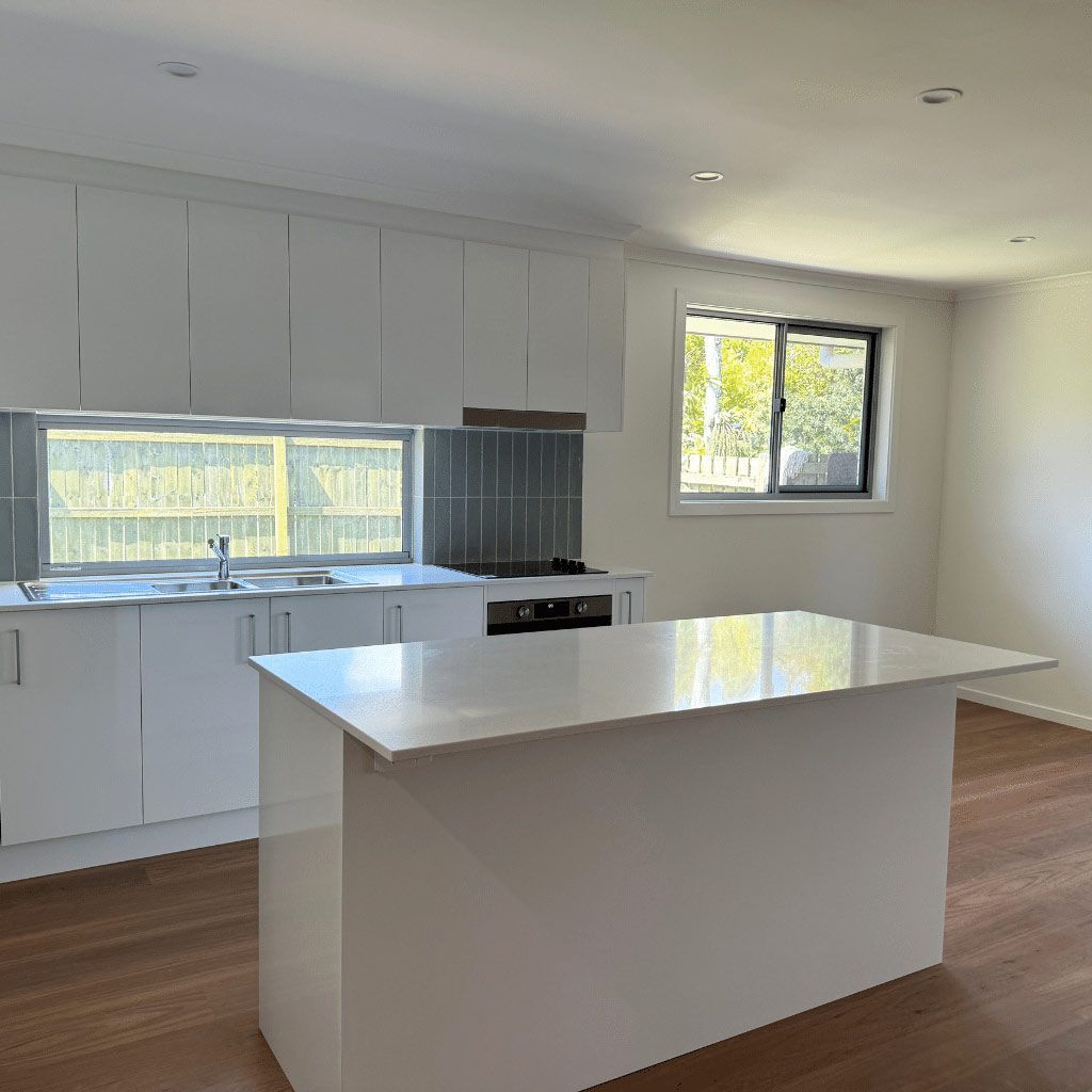Large Island In The Middle Of The Empty White Kitchen — Nyblad Construction in Caloundra West, QLD