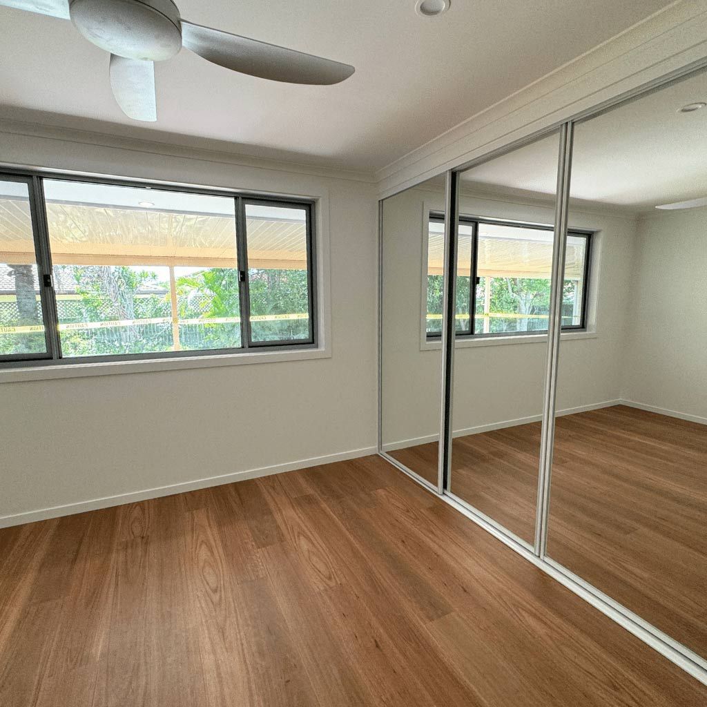 A Bedroom With Hardwood Floors — Nyblad Construction in Caloundra West, QLD