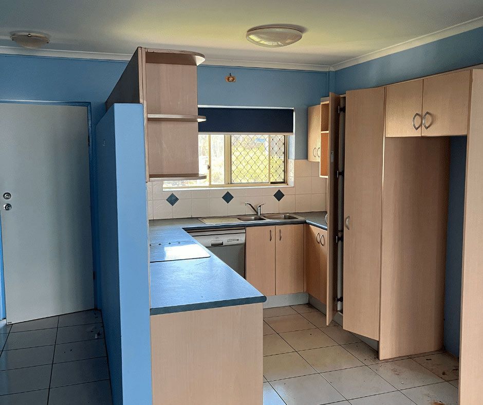 An Empty Kitchen With Blue Walls And Wooden Cabinets — Nyblad Construction in Caloundra West, QLD